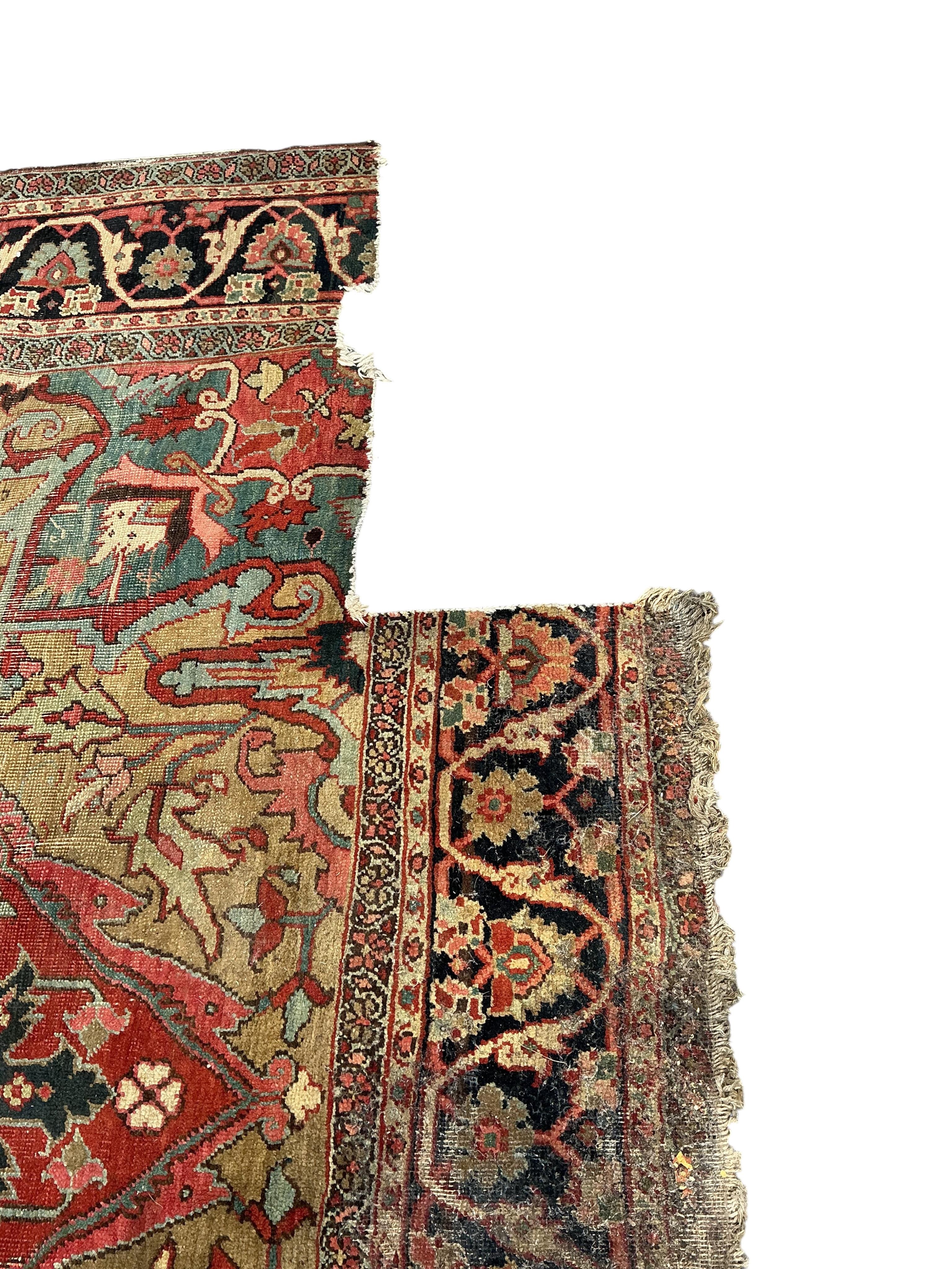 An antique Heriz pink ground carpet, worn and lacking a piece to one corner, 365 x 255cm